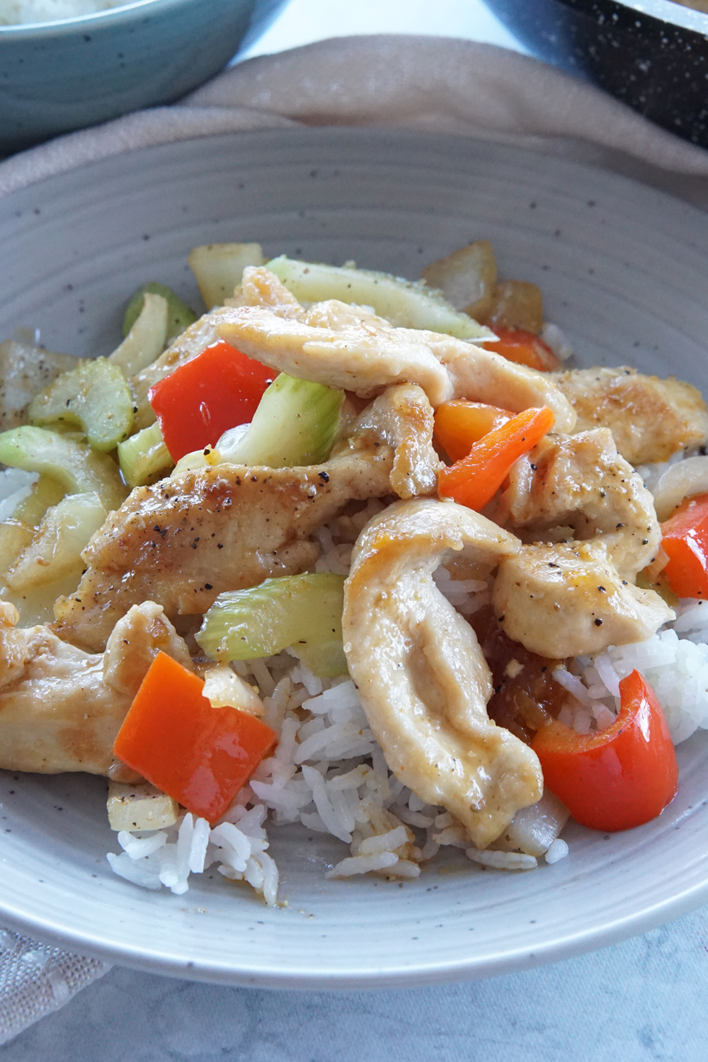 Chicken stir fry on a plate with rice.